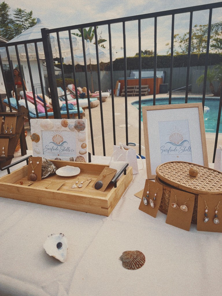 Framed Surfside Shells signs beside a jewelry tray