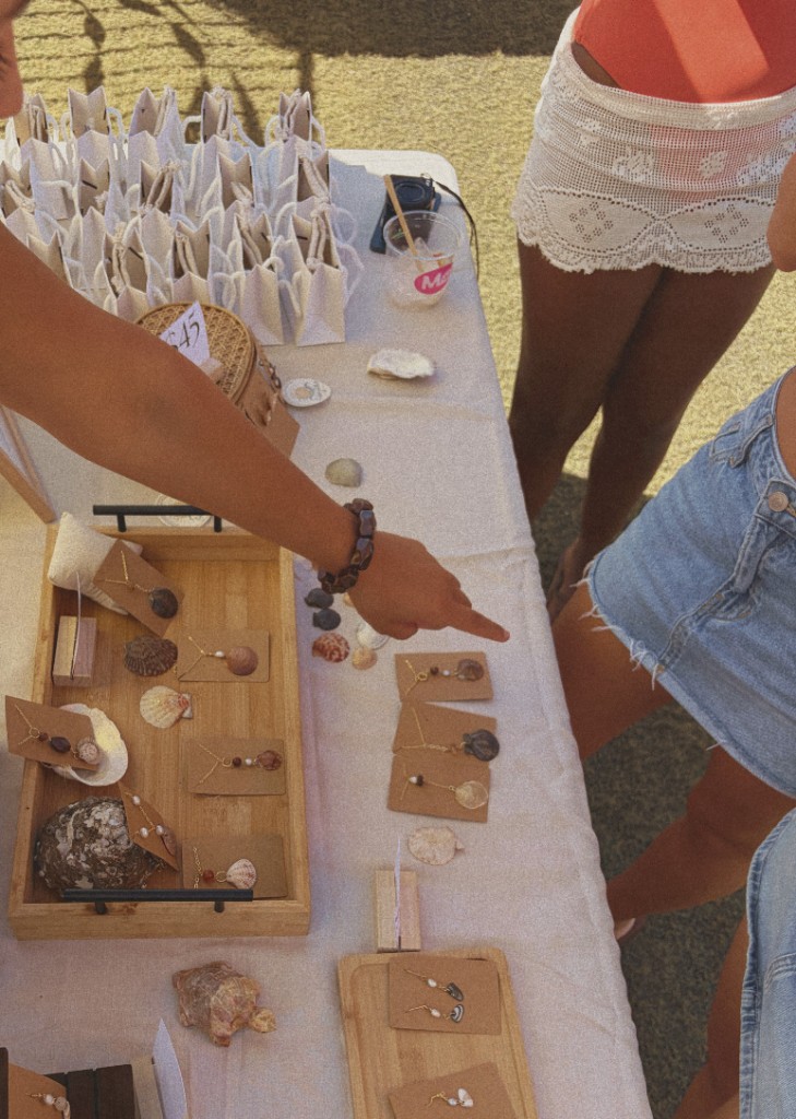 Choosing shell jewelry from a market table